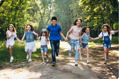 Children holding hands and running together through a park at a Cops 'n Kids event