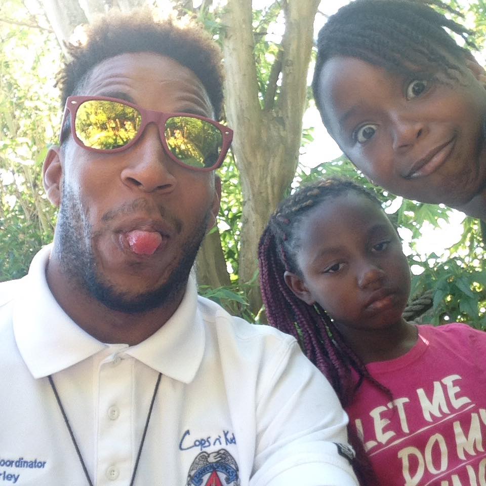 Adult and child making playful faces close to the camera at a Cops 'n Kids event