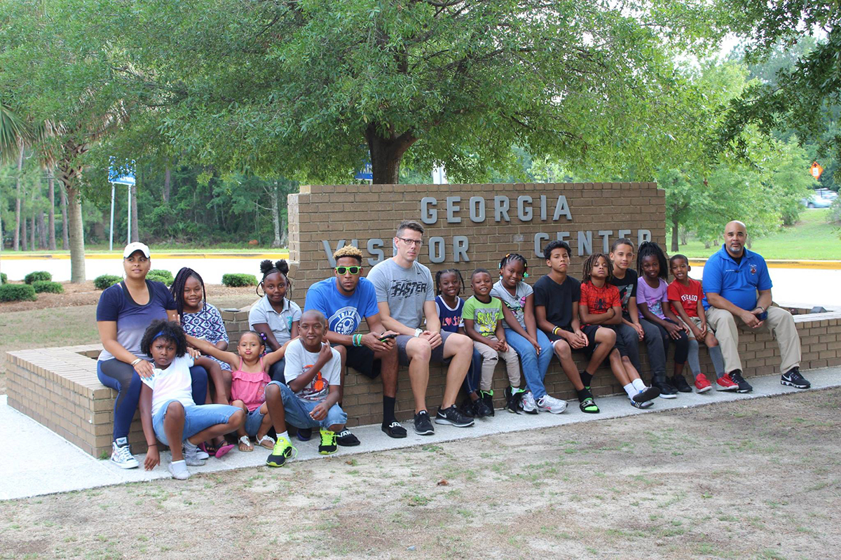 Cops 'n Kids group seated on steps in front of the Georgia Visitor Center