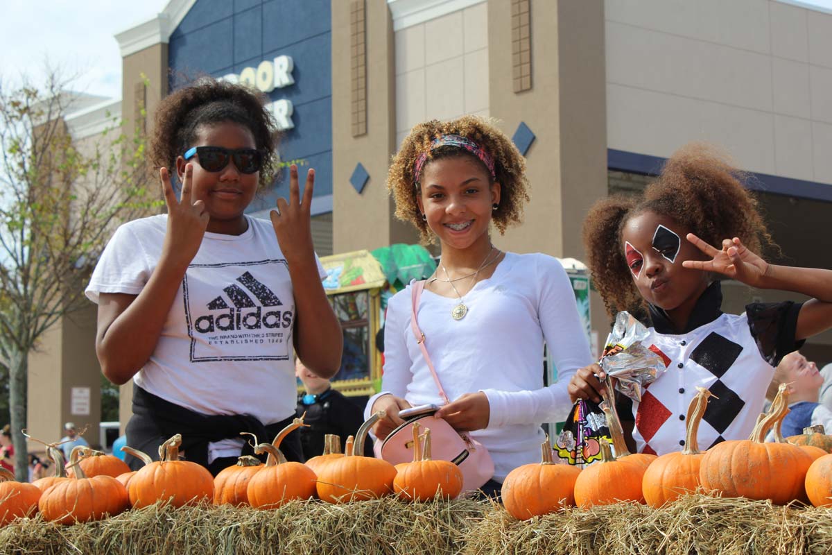 Two young girls smiling and posing at a Cops 'n Kids event, one making a peace sign